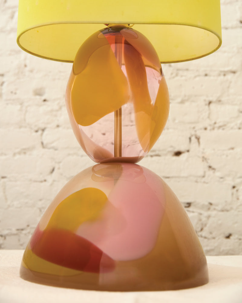 Colorful glass lamp with a yellow shade on a textured surface